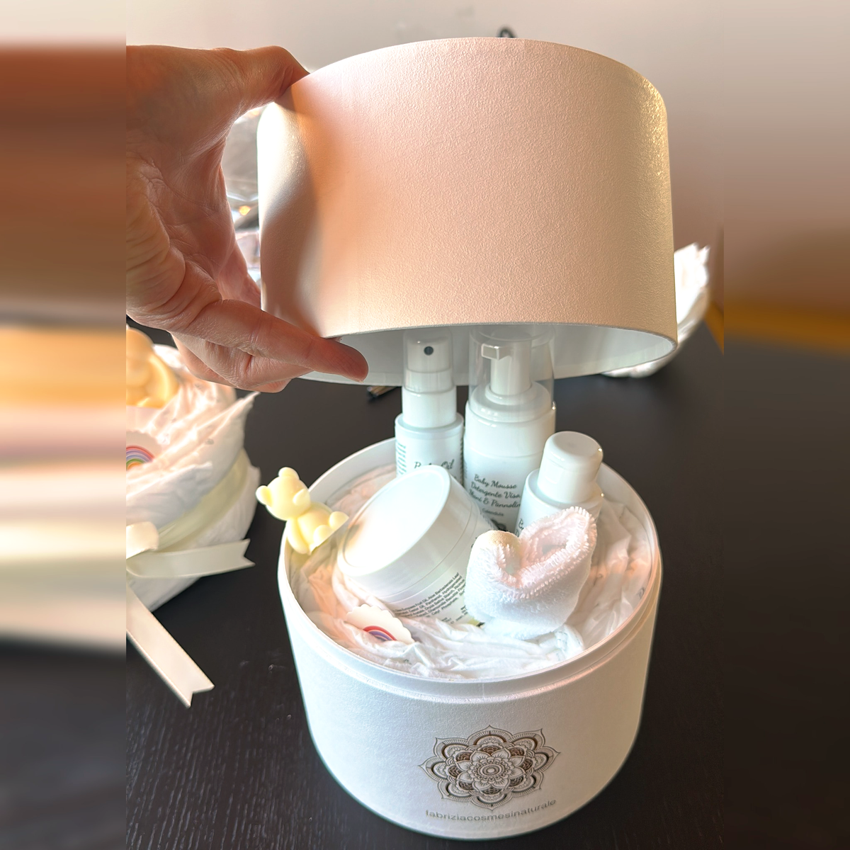 Il coperchio del box regalo che si sfila e scopre i cosmetici dentro: esempio di composizione, i cosmetici non sono compresi